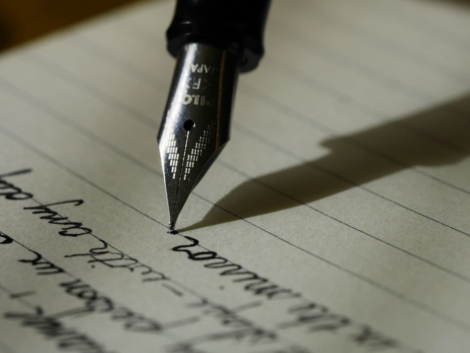 A fountain pen writing a birthday planning checklist in a lined journal